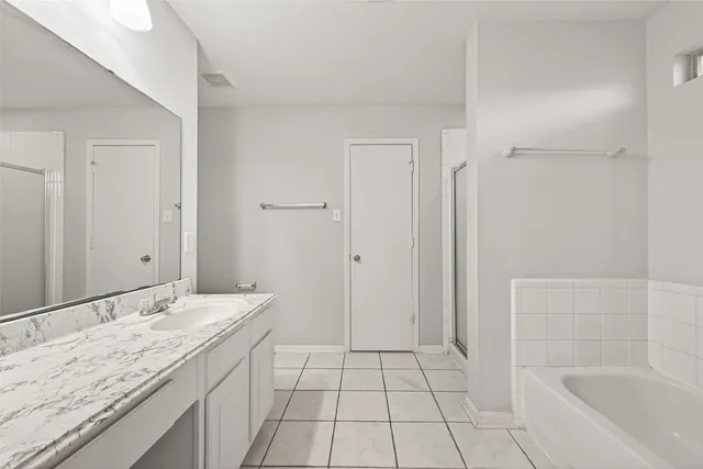 a bathroom with a granite countertop sink a mirror and a bathtub