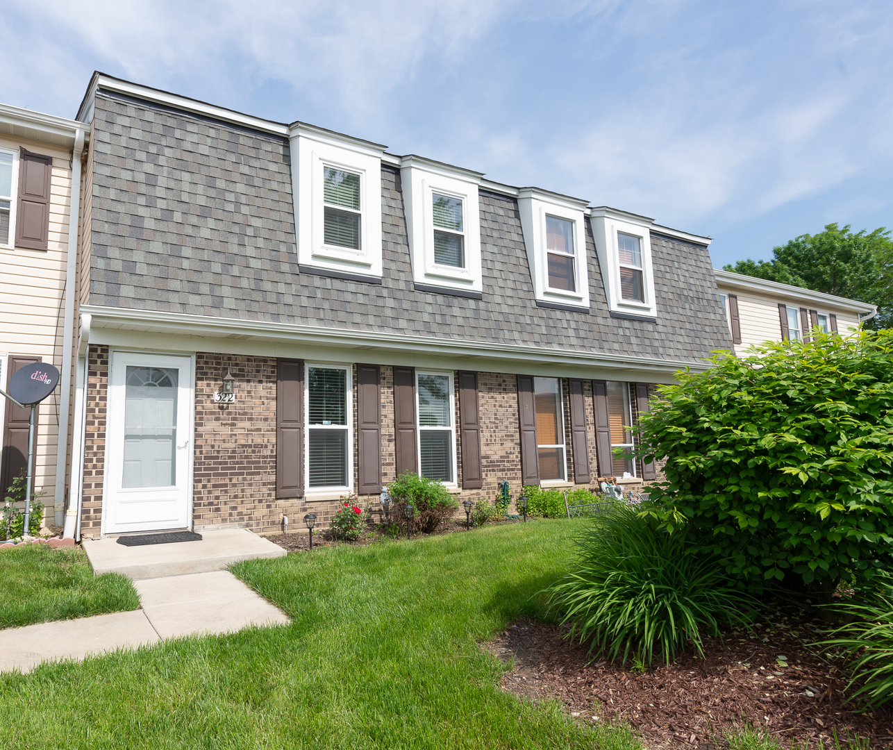 a front view of a house with yard and green space