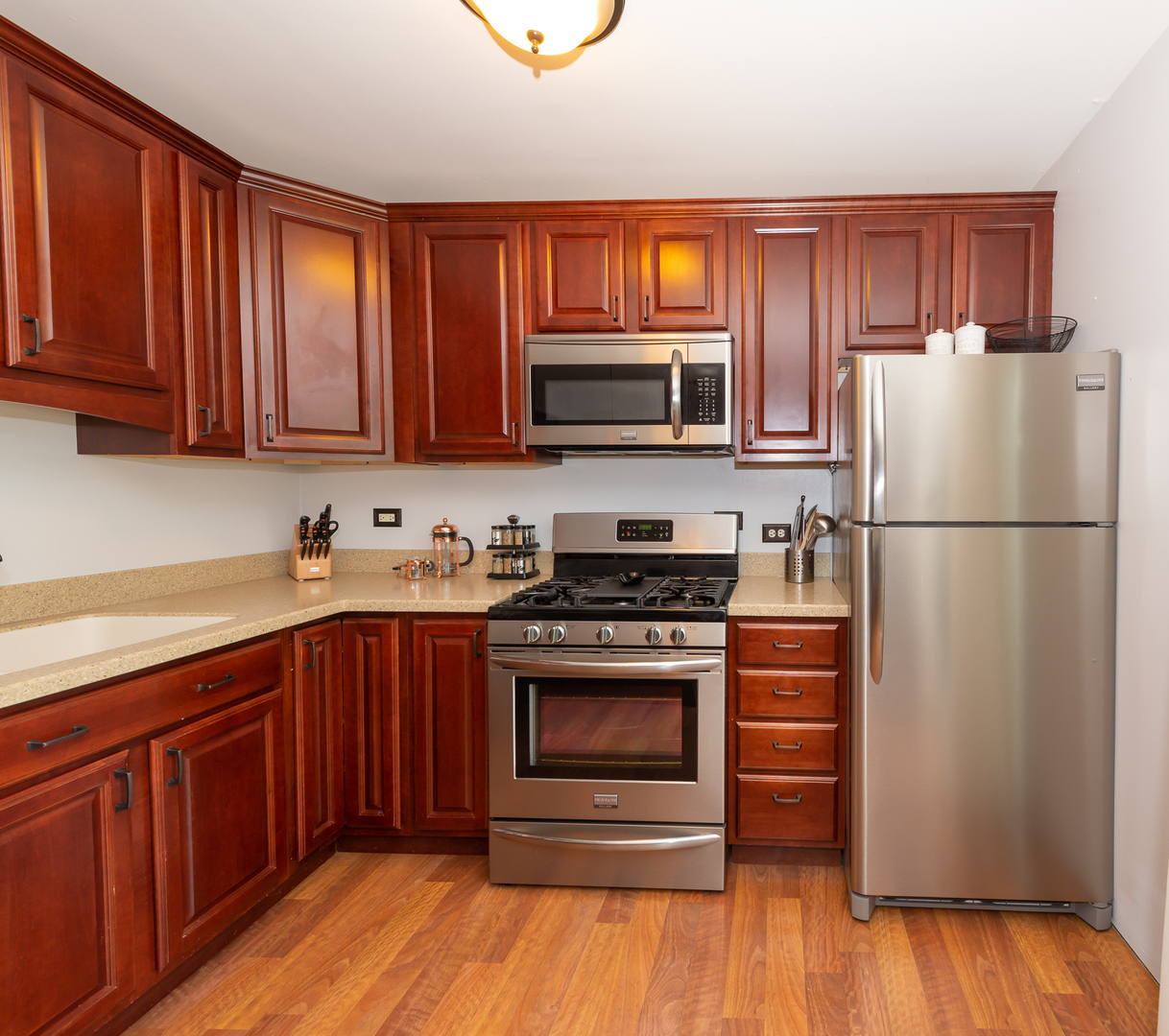 322 Rodenburg Road Roselle, IL 60172 - Photo 10 of 17 a kitchen with granite countertop wooden cabinets stainless steel appliances and a wooden floor