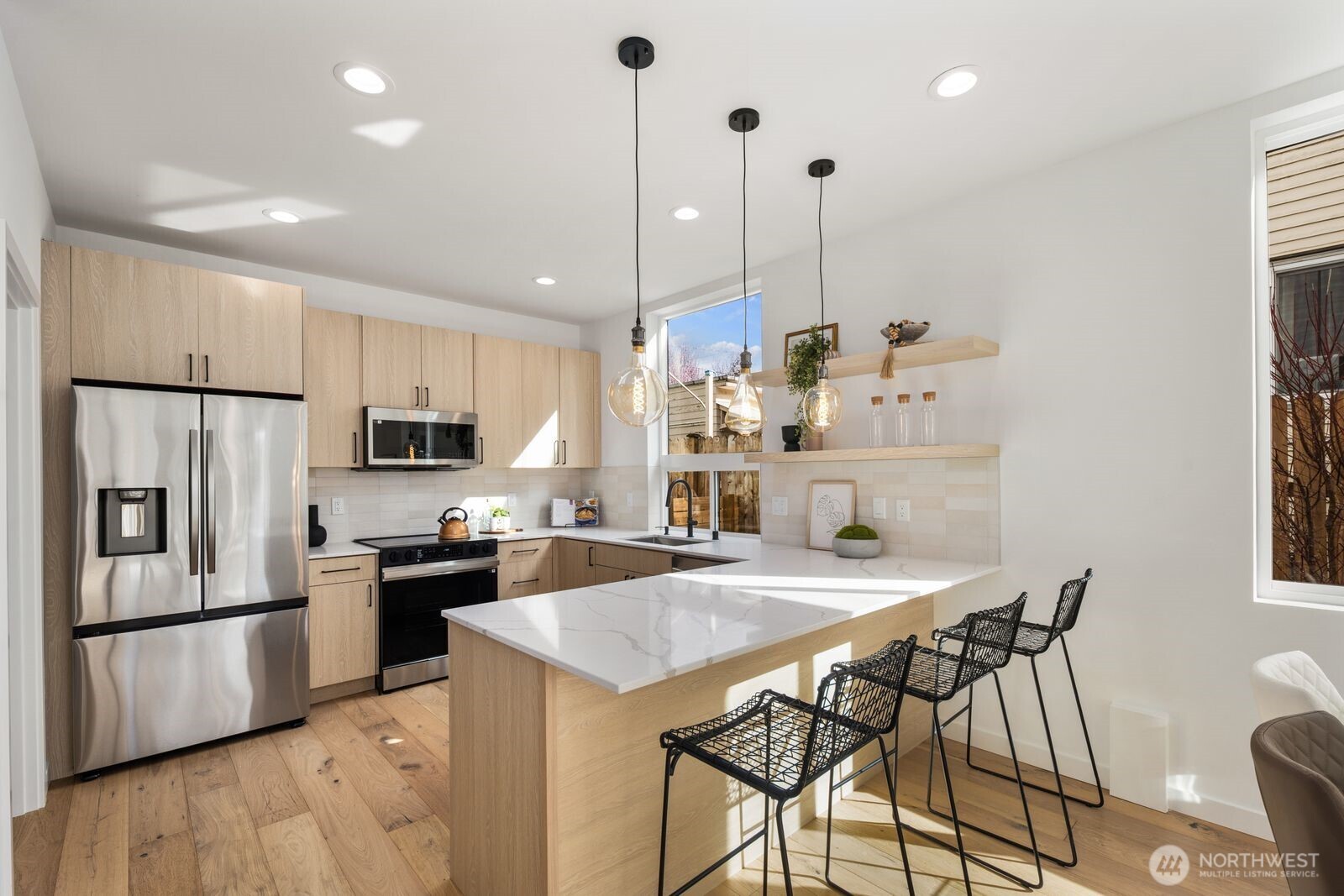520 North 102nd Street Seattle, WA 98133 - Photo 6 of 20 a kitchen with stainless steel appliances kitchen island a table chairs and a refrigerator