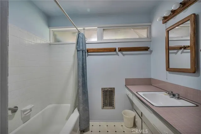 a bathroom with a granite countertop sink a mirror and a bathtub