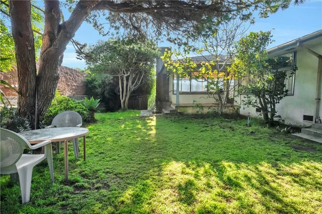 a backyard of a house with table and chairs