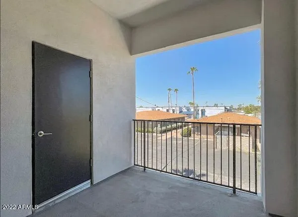 a view of an empty room with glass door and fan