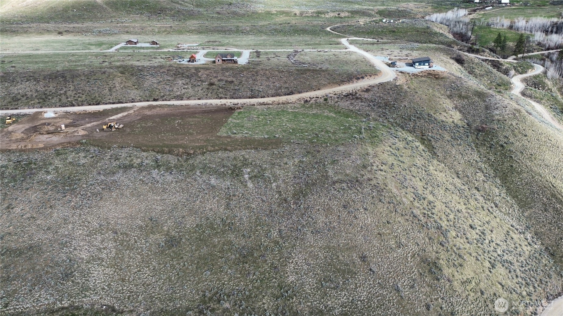 a view of a dry yard with wooden fence