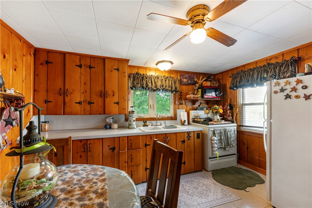 7000 Navarre Road Southwest Massillon, OH 44646 - Photo 22 of 22 The kitchen features wood paneling, wood cabinetry, white countertops, and white appliances