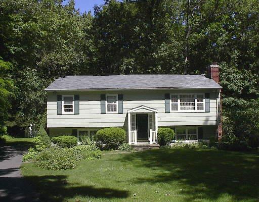 55 Ashbee Lane Ridgefield, CT 06877 - Photo 1 of 1 a front view of a house with a garden and porch