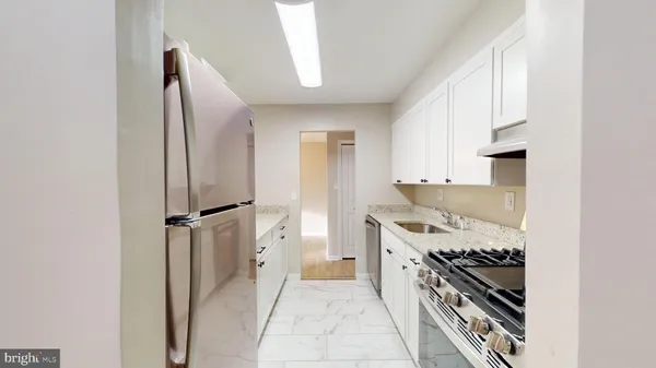 a kitchen with stainless steel appliances granite countertop a stove and a refrigerator