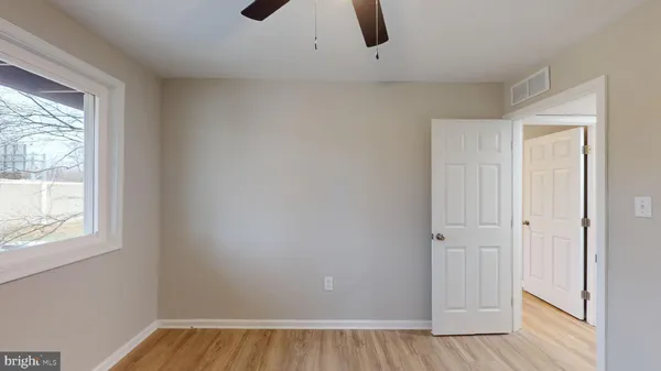 an empty room with closet and windows
