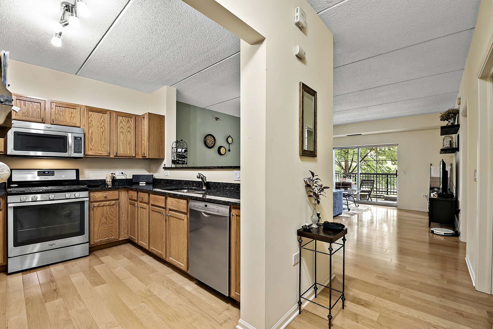 440 West Mahogany Court, Unit 208 Palatine, IL 60067 - Photo 3 of 16 a kitchen with stainless steel appliances granite countertop a stove top oven a sink dishwasher a dining table and chairs with wooden floor