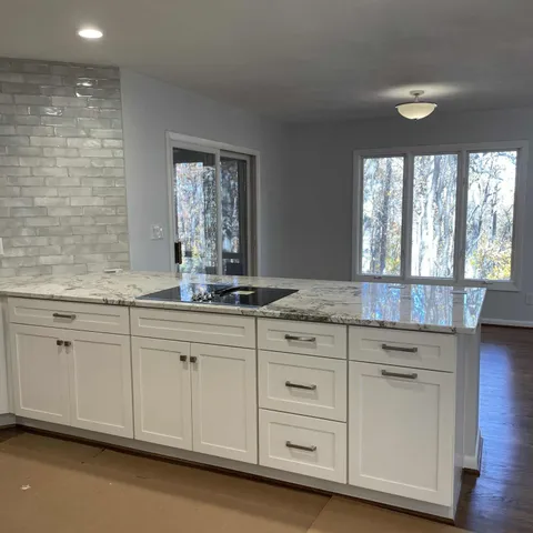 a kitchen with granite countertop white cabinets and a sink