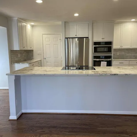 a view of kitchen with stainless steel appliances granite countertop a stove a sink and a refrigerator