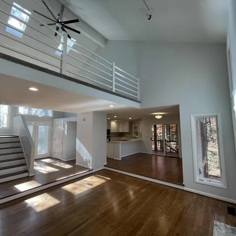 a view of a hallway with wooden floor and a ceiling fan