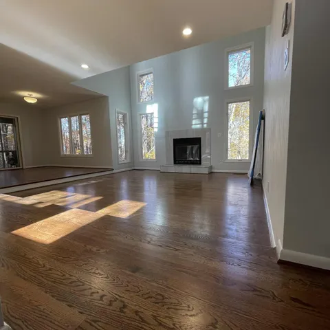 an empty room with wooden floor and fireplace
