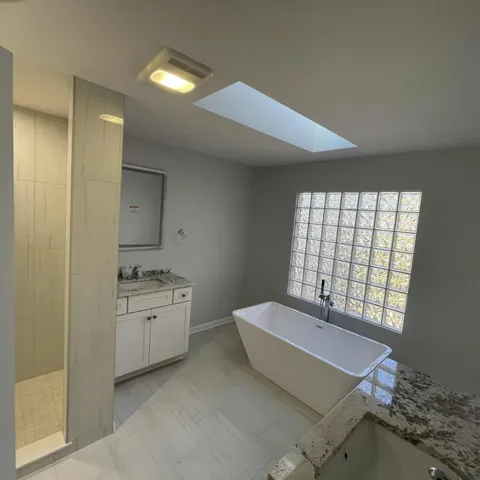 a spacious bathroom with a granite countertop sink a toilet and a mirror