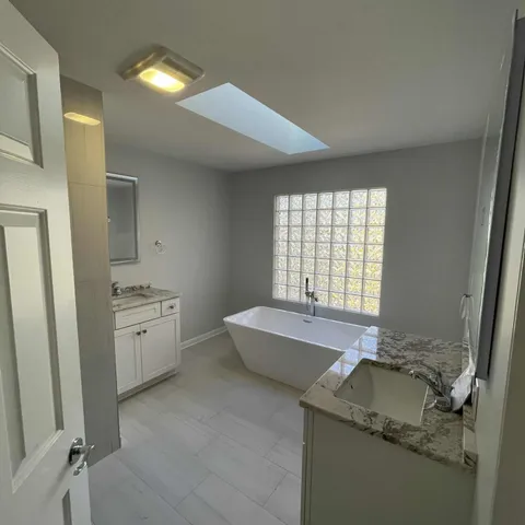 a spacious bathroom with a granite countertop tub sink and mirror
