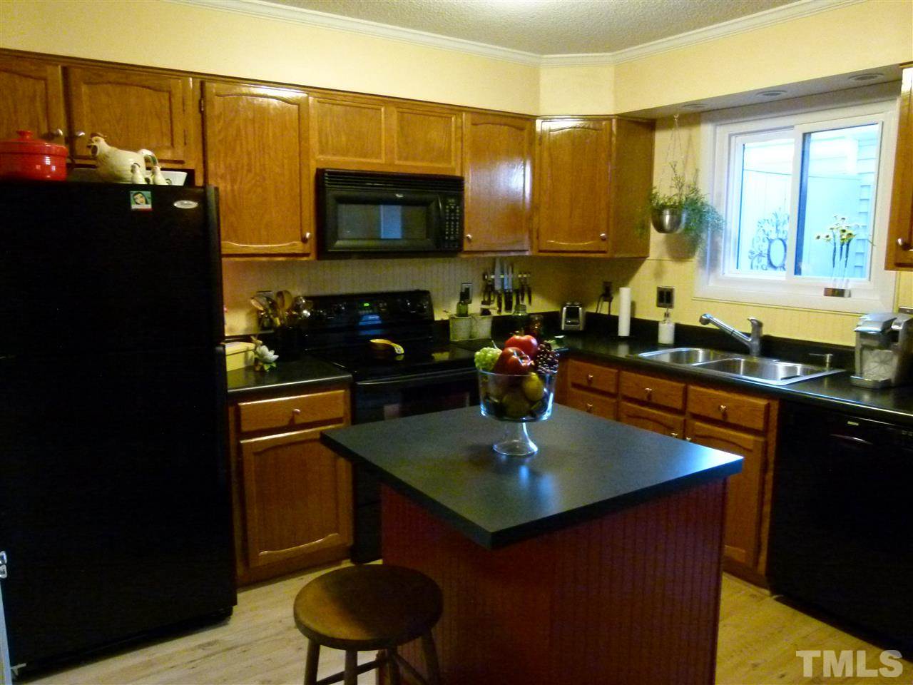 6967 Staghorn Lane Raleigh, NC 27615 - Photo 2 of 11 a kitchen with a sink a counter and cabinets