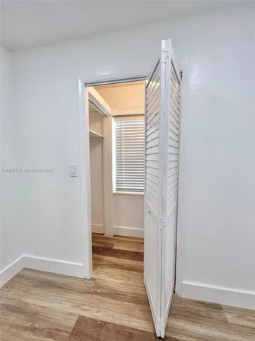 a view of a livingroom with wooden floor and window