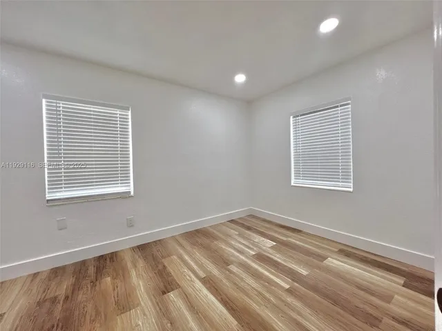 a view of a room with wooden floor and windows