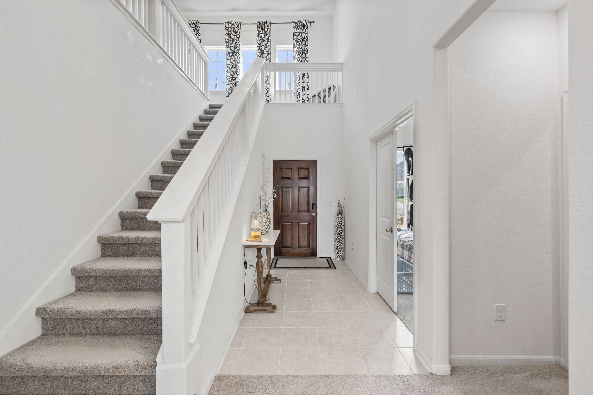 189 Durian Loop Buda, TX 78610 - Photo 5 of 38 Entryway with a towering ceiling, stairway, plenty of natural light, and light tile patterned floors