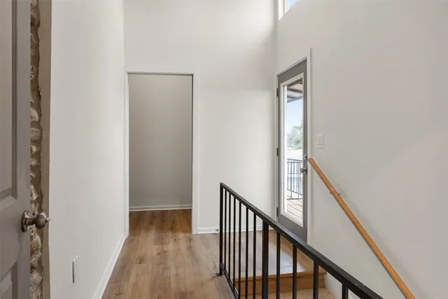 a view of a hallway with wooden floor and staircase