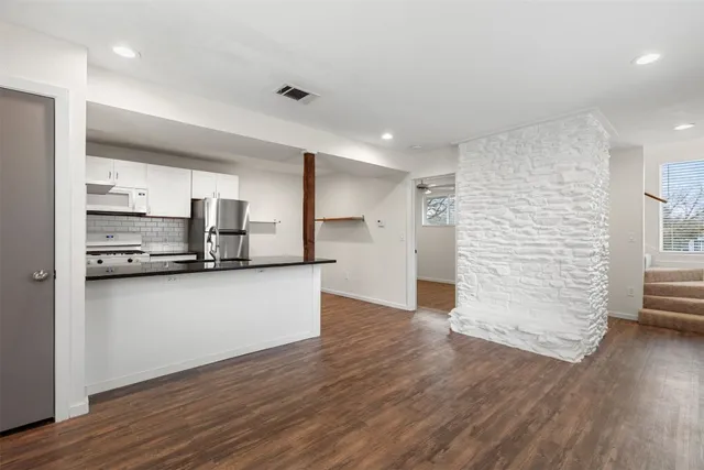 a view of kitchen with wooden floor and electronic appliances