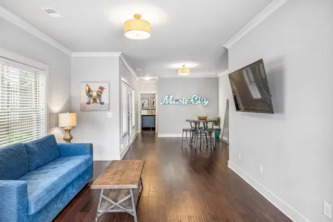 a living room with furniture and a wooden floor