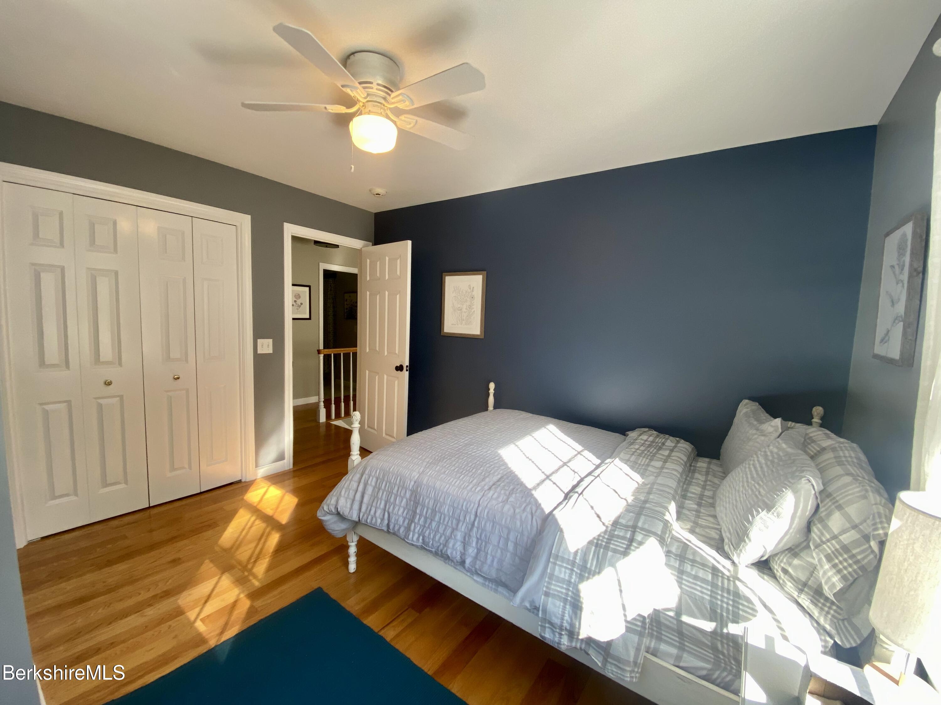 199 Old Post Road Richmond, MA 01201 - Photo 25 of 40 a bedroom with a bed and a chandelier