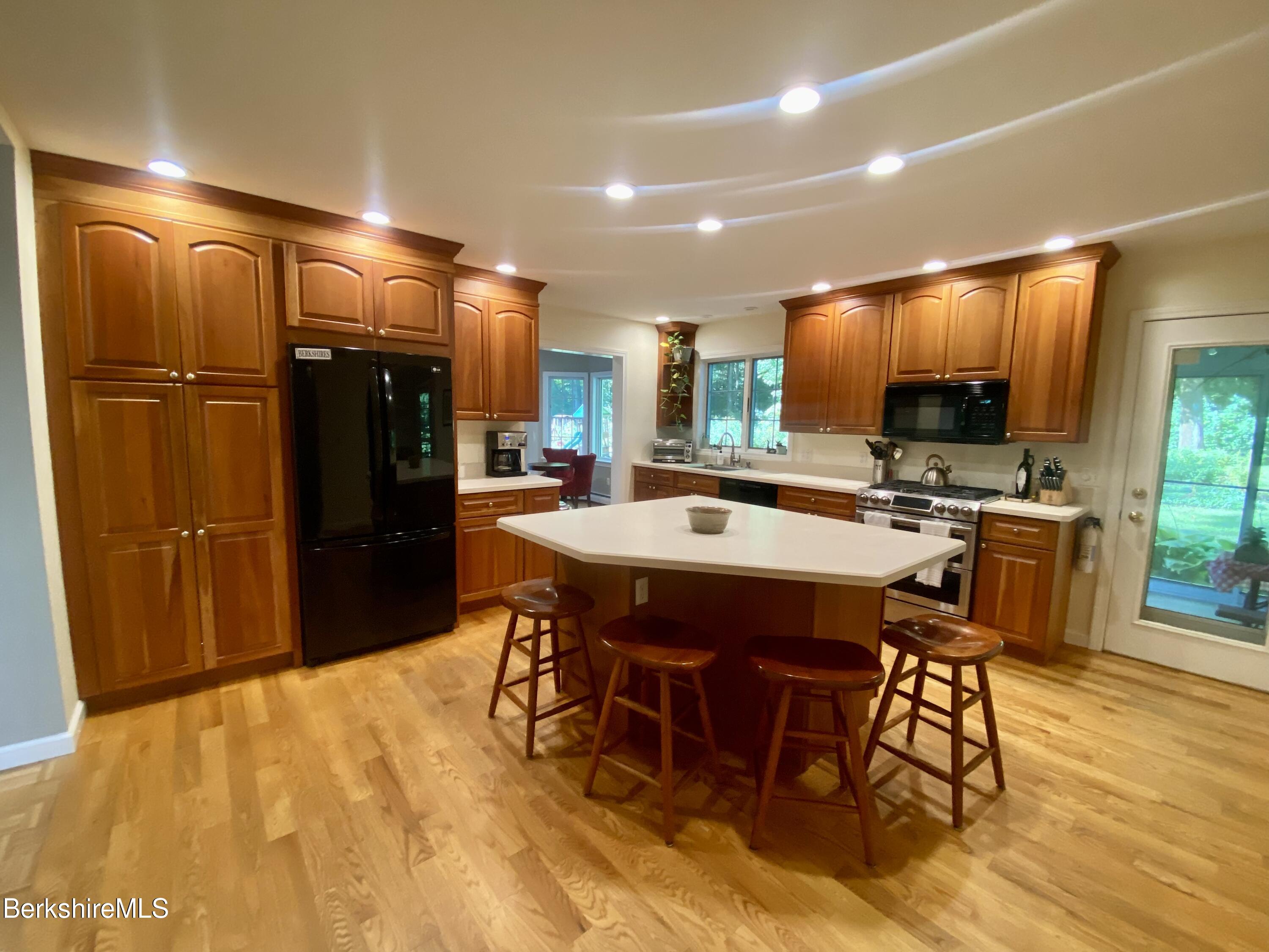 199 Old Post Road Richmond, MA 01201 - Photo 7 of 40 a kitchen with a table chairs refrigerator and microwave