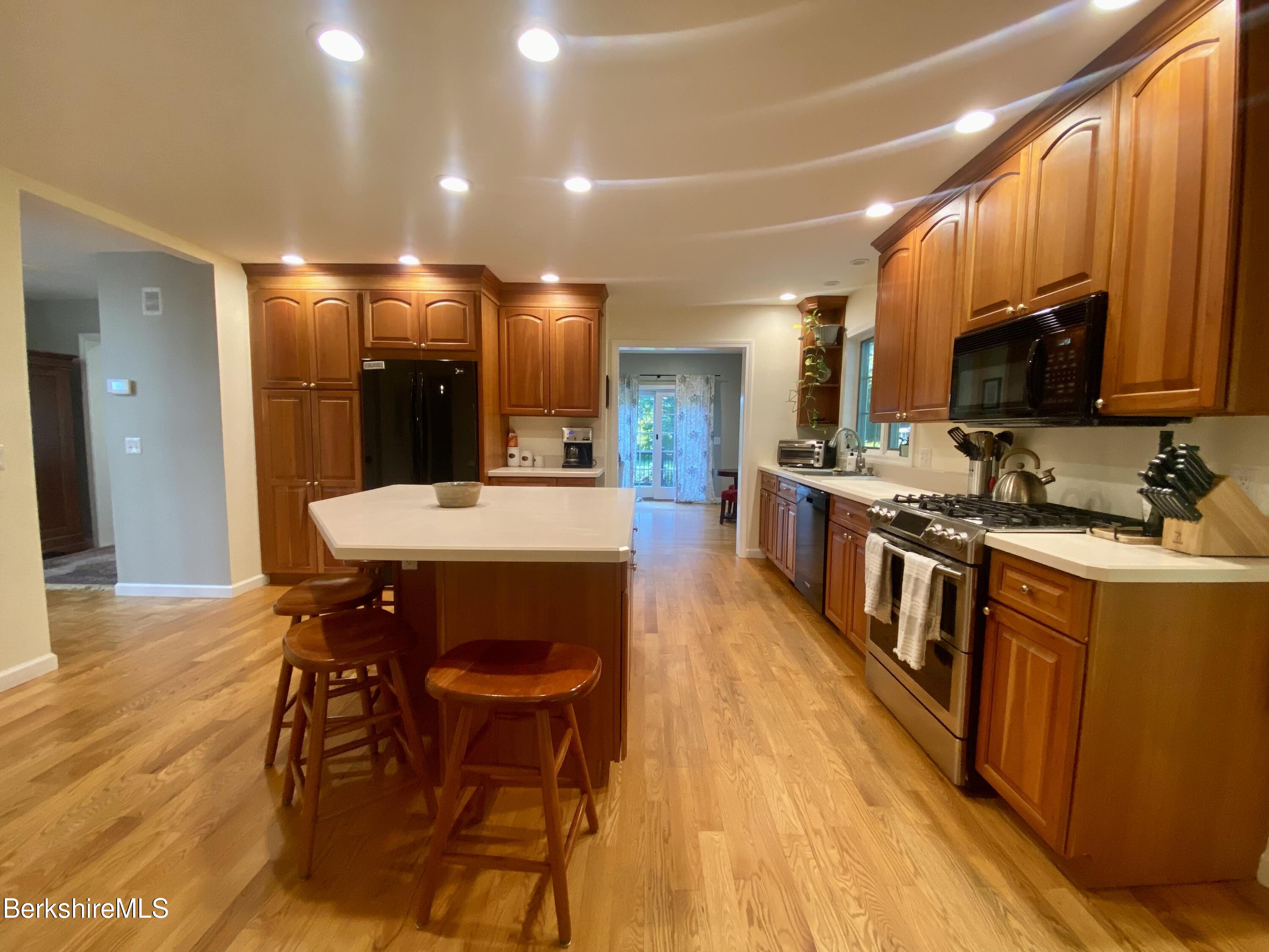199 Old Post Road Richmond, MA 01201 - Photo 9 of 40 a kitchen with stainless steel appliances kitchen island granite countertop a table chairs and a sink