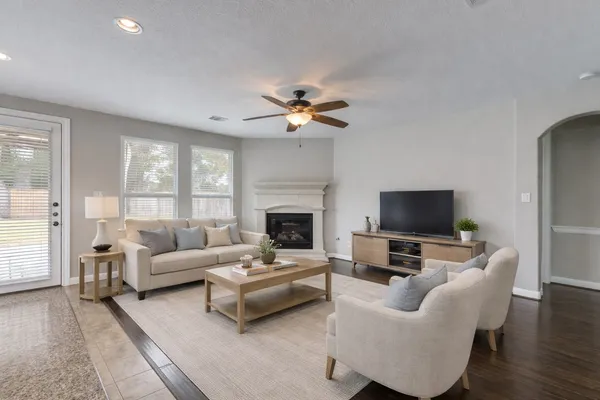 a living room with furniture a fireplace and a flat screen tv