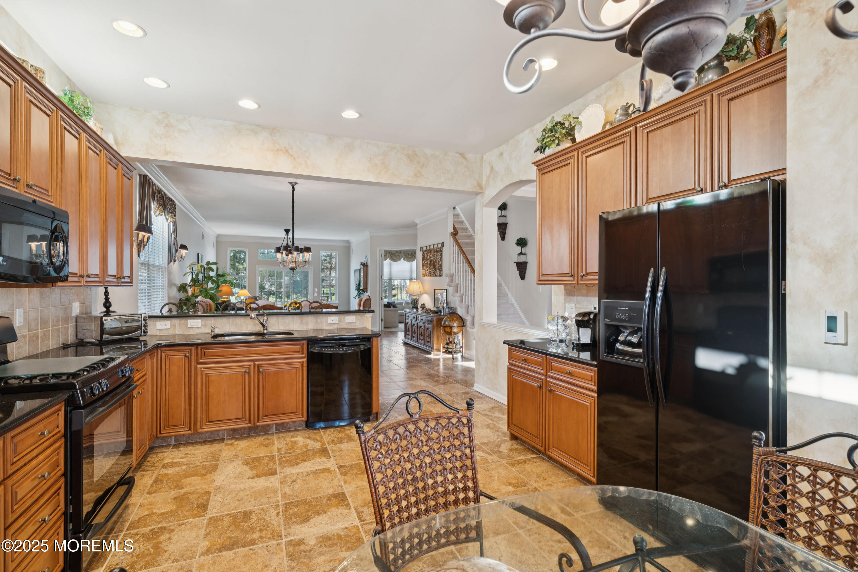 66 Crooked Stick Road Jackson, NJ 08527 - Photo 6 of 25 a kitchen with stainless steel appliances granite countertop a refrigerator a stove a sink dishwasher a dining table and chairs with wooden floor
