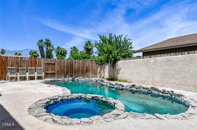 a backyard of a house with table and chairs