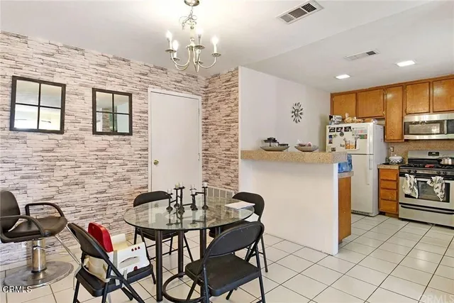 a kitchen with stainless steel appliances kitchen island granite countertop a refrigerator a stove a sink dishwasher with a dining table and chairs