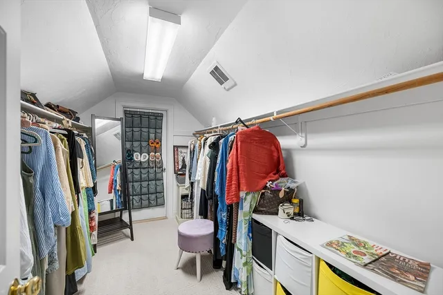 a view of walk in closet with clothes and shoes