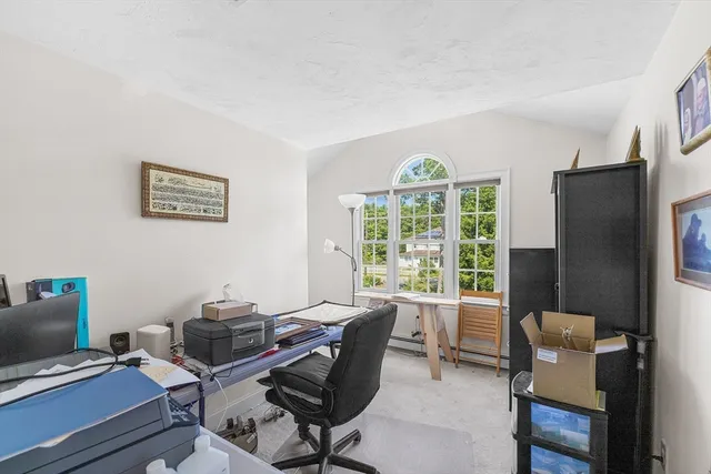 a view of a workspace with furniture and a window