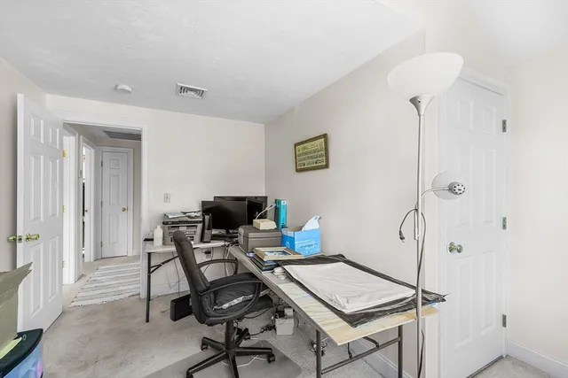 a view of a workspace with furniture and a window