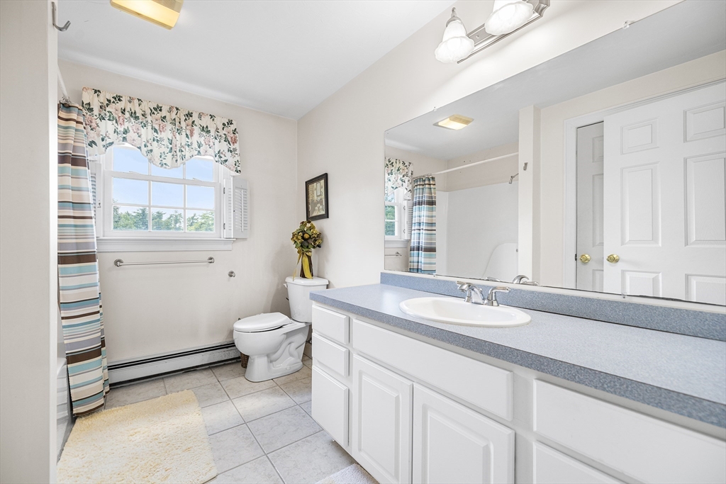 898 Main Street West Wareham, MA 02576 - Photo 30 of 36 a bathroom with a granite countertop sink a toilet a mirror and a window