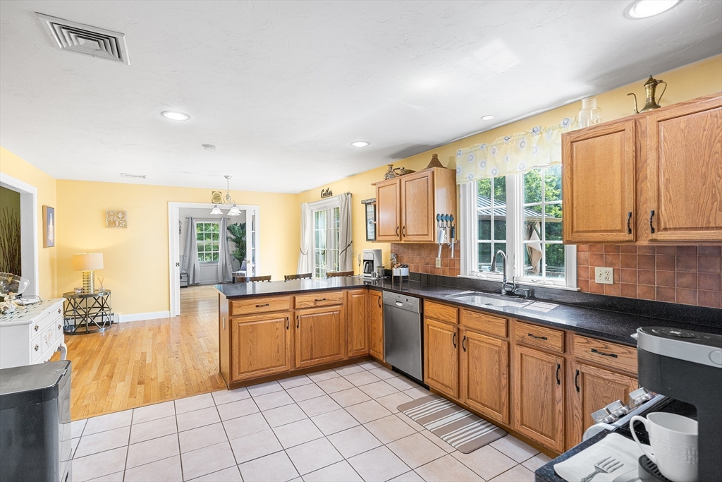 898 Main Street West Wareham, MA 02576 - Photo 8 of 36 a large kitchen with kitchen island granite countertop a sink and white cabinets