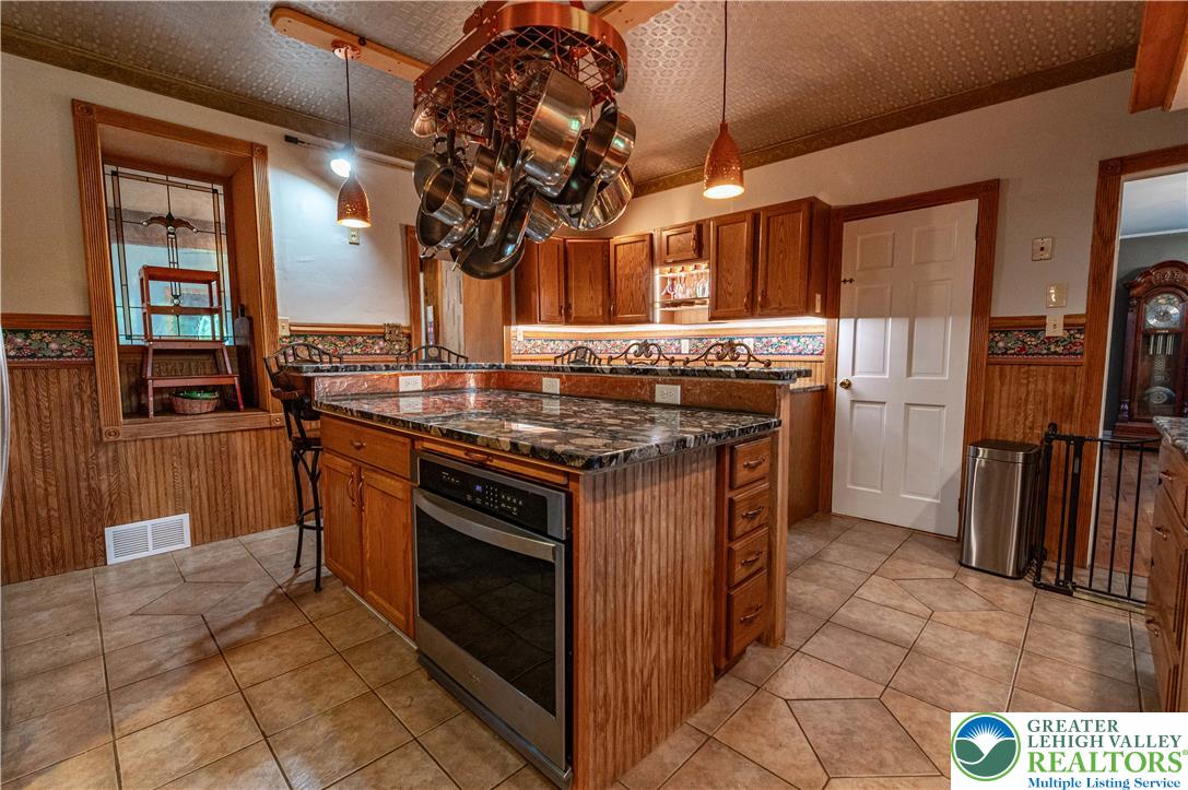 2485 Hieter Road Quakertown, PA 18951 - Photo 13 of 97 A gourmet kitchen boasts granite counters, warm wood cabinetry, and a convenient pot rack.