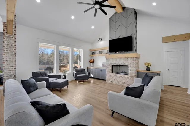 a living room with furniture a flat screen tv and a fireplace