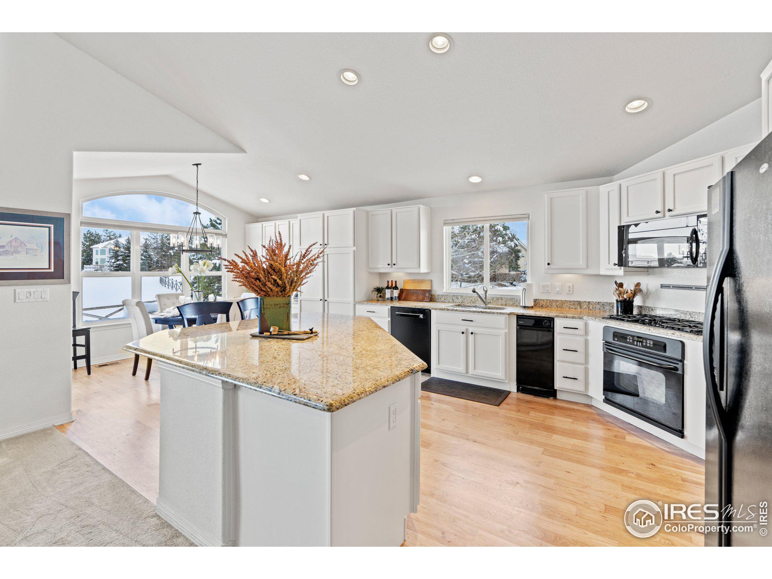 a kitchen with stainless steel appliances a sink a stove a refrigerator cabinets and a center island