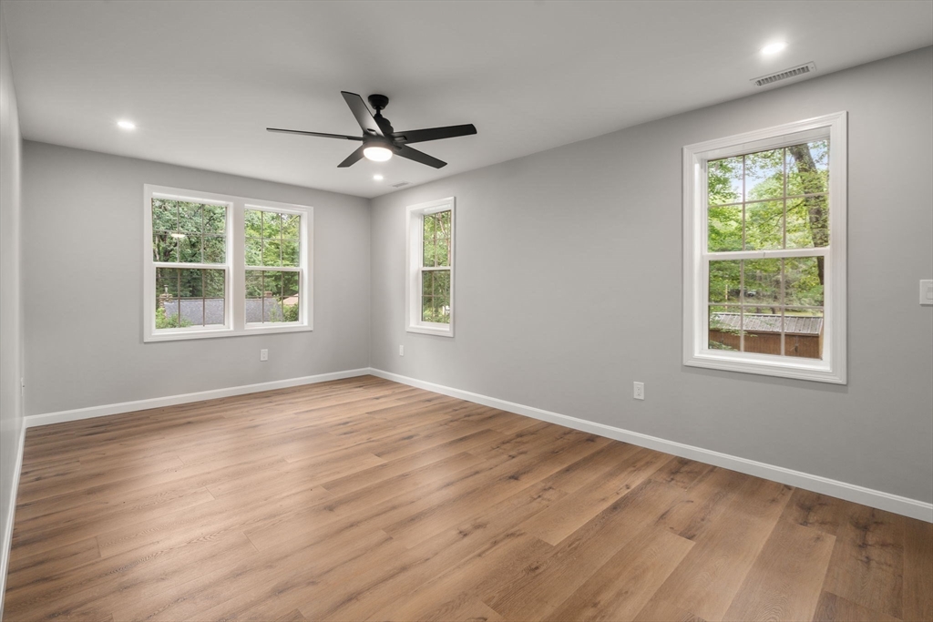 75 Hiland Road Charlton, MA 01507 - Photo 14 of 38 an empty room with wooden floor ceiling fan and windows