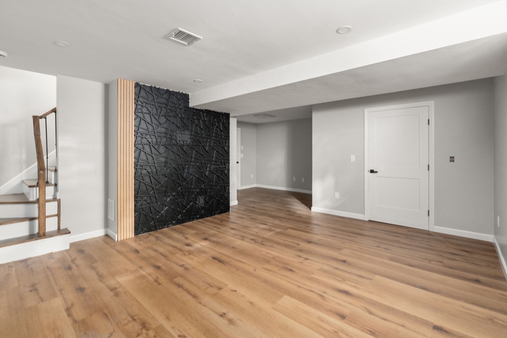 75 Hiland Road Charlton, MA 01507 - Photo 24 of 38 a view of an empty room with wooden floor and kitchen view
