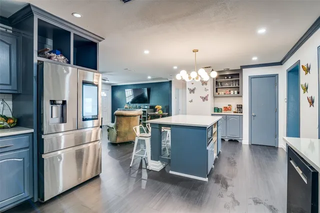 a kitchen with stainless steel appliances kitchen island granite countertop a refrigerator and a stove top oven