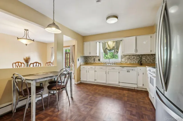 a kitchen with a table chairs refrigerator and window