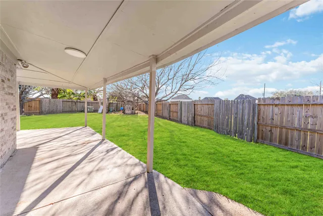 a view of a backyard with wooden fence