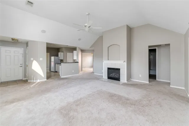 an empty room with a fireplace and chandelier