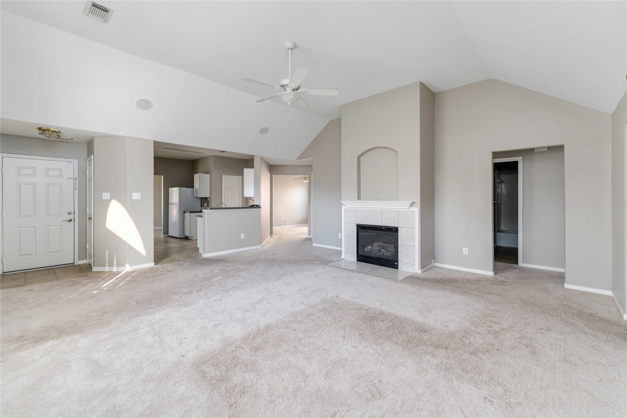 12106 Landsdown Ridge Way Humble, TX 77346 - Photo 3 of 23 an empty room with a fireplace and chandelier