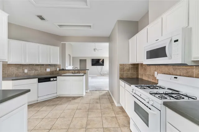 a kitchen with granite countertop a stove top oven microwave and cabinets