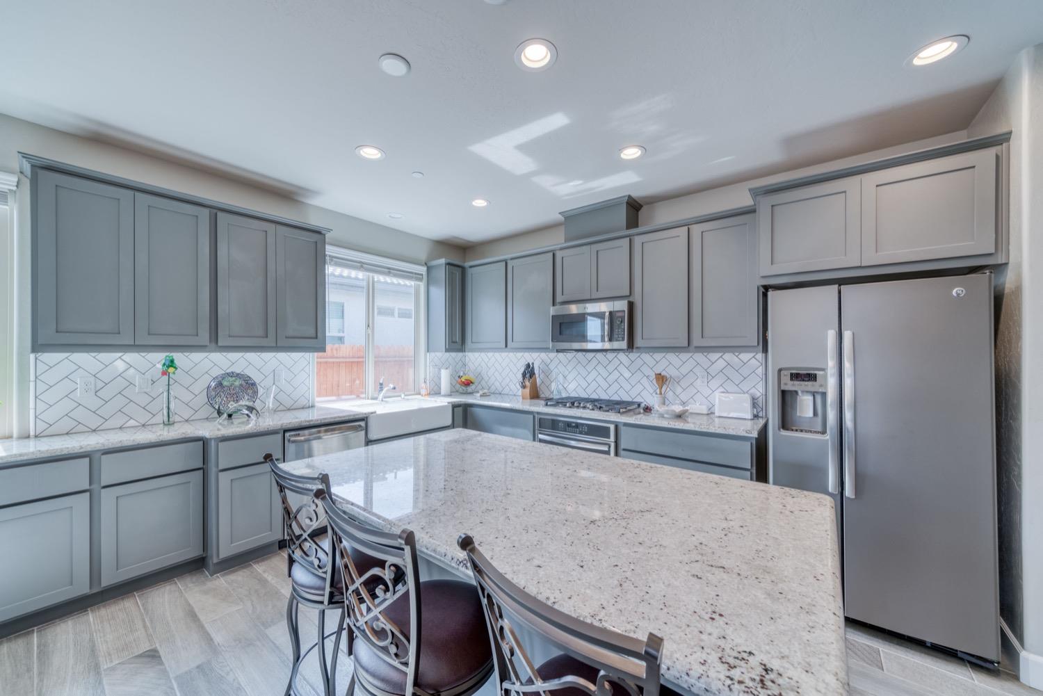 1009 Skylar Lane Clovis, CA 93619 - Photo 5 of 32 a kitchen with a table chairs refrigerator and microwave